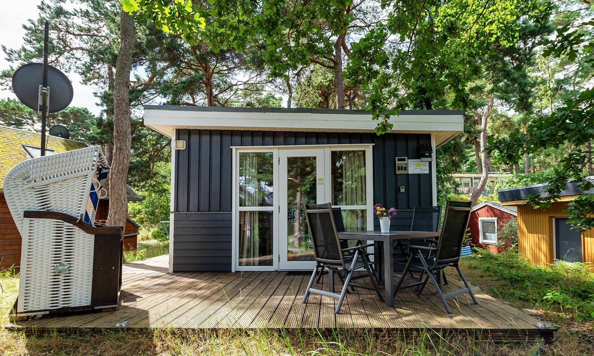 Gohren House | Achtern Dieck 68e Vacation Home in Baabe. A sunny terrace with its own beach chair and an idyllic view of the Baltic Sea through the trees. Comfortable living with underfloor heating
