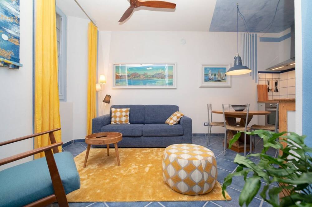 Arona Apartment | Charming one-bedroom apartment, finely furnished, located on the ground floor of Via Pertossi in the historic centre of Arona.Casa Azzurra is a 52 sqm one-bedroom apartment with air conditioning, featuring a living room/kitchen area with a double sofa be