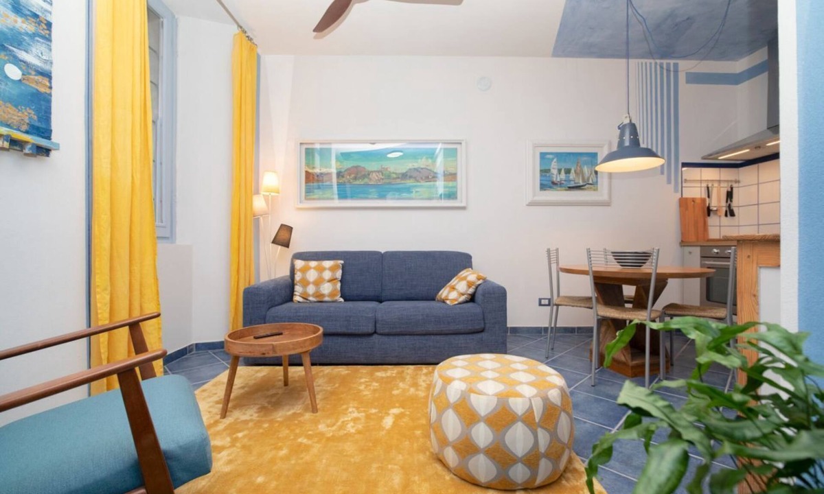 Arona Apartment | Charming one-bedroom apartment, finely furnished, located on the ground floor of Via Pertossi in the historic centre of Arona.Casa Azzurra is a 52 sqm one-bedroom apartment with air conditioning, featuring a living room/kitchen area with a double sofa be