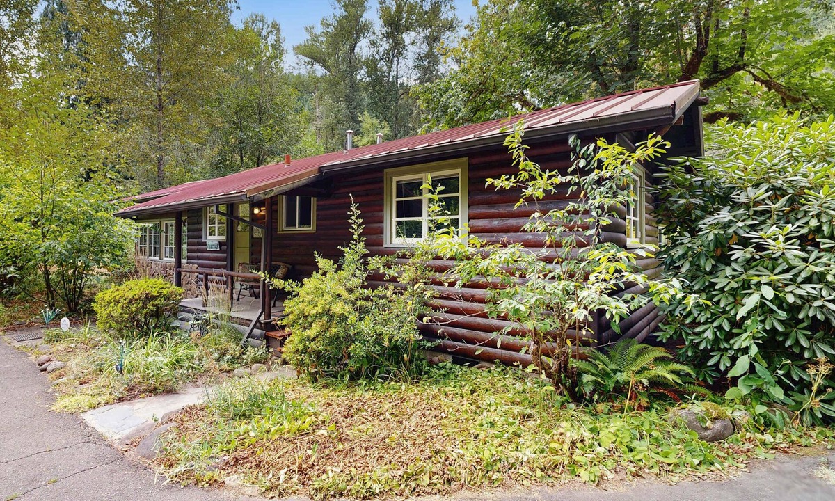 Molalla House | Tranquil landscape with riverside firepit, gas grill, gas fireplace, and deck