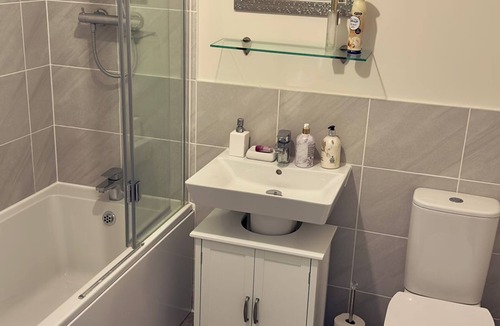 Milton Keynes House | A light spacious room,with sofa and single bed. Private bathroom with shower.