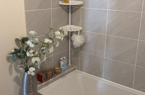 Milton Keynes House | A light spacious room,with sofa and single bed. Private bathroom with shower.