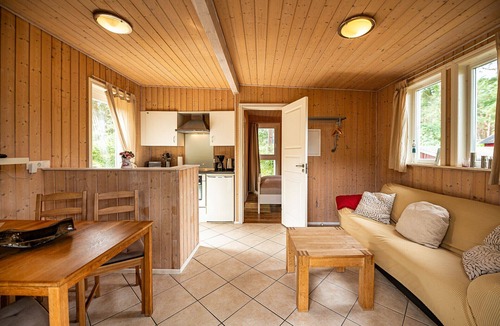 Gohren House | Achtern Dieck 68e Vacation Home in Baabe. A sunny terrace with its own beach chair and an idyllic view of the Baltic Sea through the trees. Comfortable living with underfloor heating