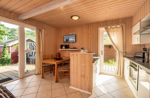 Gohren House | Achtern Dieck 68e Vacation Home in Baabe. A sunny terrace with its own beach chair and an idyllic view of the Baltic Sea through the trees. Comfortable living with underfloor heating