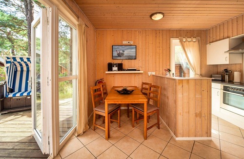 Gohren House | Achtern Dieck 68e Vacation Home in Baabe. A sunny terrace with its own beach chair and an idyllic view of the Baltic Sea through the trees. Comfortable living with underfloor heating