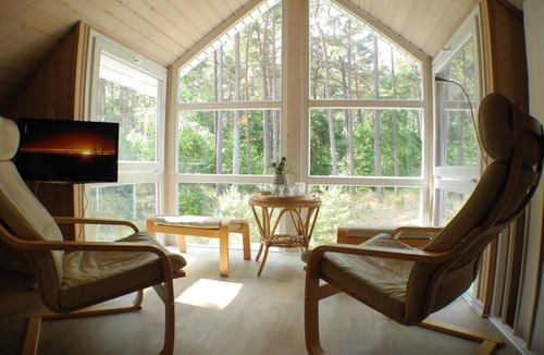 Gohren House | Austernperle 258 Vacation Home in Baabe. Relax in the hot tub and in your own sauna. Cozy evenings by the fireplace. A terrace right on the edge of the forest with exclusive teak lounge chairs. One parking space included