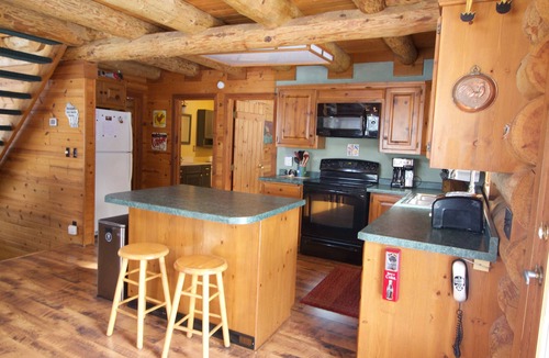 Egg Harbor House | Beautiful log home with wrap-around deck surrounded by trees.