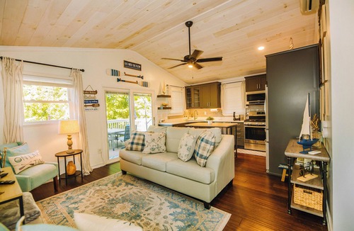 New River House | Charming lakeside retreat with serene views, cozy interiors, spacious deck, and lush outdoor spaces.