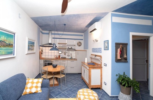 Arona Apartment | Charming one-bedroom apartment, finely furnished, located on the ground floor of Via Pertossi in the historic centre of Arona.Casa Azzurra is a 52 sqm one-bedroom apartment with air conditioning, featuring a living room/kitchen area with a double sofa be