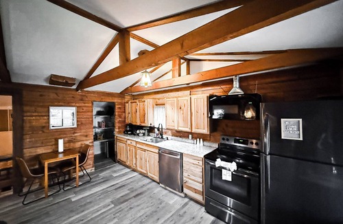 Lake Ozark House | Escape to Grandpa John’s Cabin in Four Seasons near Shady Gators & Camden on the Lake. This restored 2 bed, 2 bath log cabin features a king suite, bunk room, fireplace, coffee bar, deck, firepit, pet-friendly stay, and parking for cars & small boat.