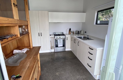 Manly House | Experience a Kiwi beach holiday here, a couple of minutes walk to the sand .