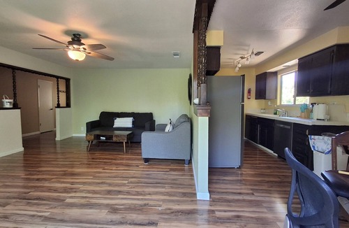 Redding House | Hillside home with large deck in a woodsy area.