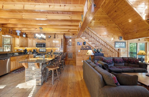 Ellijay Cabin | Ideal for large families, this riverfront gem boasts a dock, firepit, hot tub, basketball court, and a pool table for endless fun. Pet Friendly and WiFi