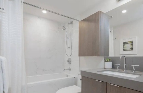 South Lake Union House | Level Seattle- Executive Two Bedroom Suite with separate office space, bedroom with king bed, full kitchen, living & dining area, private balcony, in-suite laundry, modern bathroom with Malin + Goetz amenities.