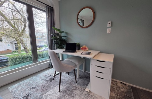 Hastings House | Modern home on a corner lot with large lawn area and patio with hot tub.