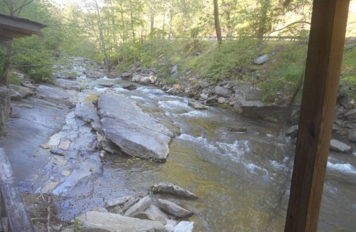 Bat Cave Cottage | On the River's Edge! Rocking chairs on large screened porch on river's edge.
