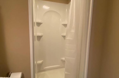 Maxwell House | Private basement bedroom with private bathroom, kitchen, and living room with large screen television