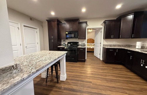 Caseyville Apartment | Private one-bedroom suite with king bed, walk-in closet, and ensuite bath featuring double vanity and safety grab bars. Enjoy serene pond views from your patio, full kitchen, and dedicated workspace for a comfortable stay.