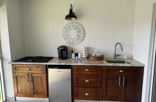 Naples Condo | Relax on the oversized lanai featuring an outdoor kitchen and mid-water view.