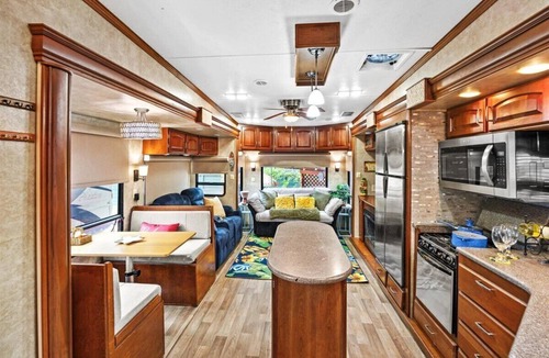 Milton RV Rental | THIS IS AN AWESOME 36' RENTAL CAMPER WITH AMAZING LONG DECK, PLUS A SECOND STEP-DOWN DECK TO YOUR OWN PRIVATE HIDEAWAY TIKI BAR! A BEAUTIFUL HUGE LIVE OAK COVERS THE ENTIRE LOT SO IT'S ALWAYS SHADED, AND THIS EVEN COMES WITH A TABLE & CHAIRS FOR OUT