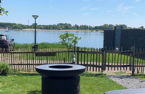 Lathum House | Tiny house Holland by the lake and beach. Fenced garden, outdoor shower and fireplace.