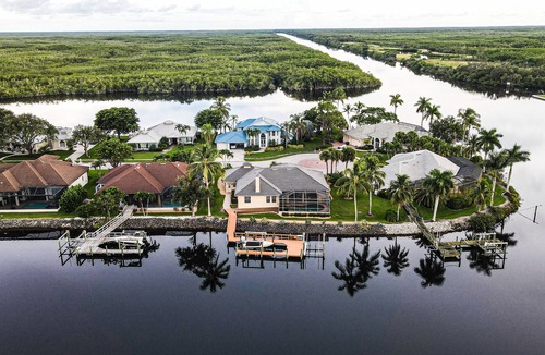 Naples House | Upscale waterfront home with private dock, saltwater pool, lanai, grill, & W/D