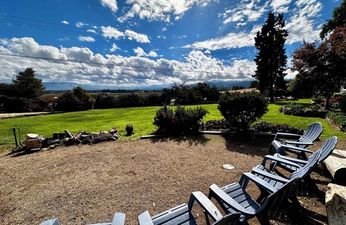 Medford Cottage | Wake to breathtaking sunrises over the rolling hills! Relax by the fire under the stars, & savor sunset dinners beneath fragrant wisteria pergola. Surrounded by wineries and minutes from historic Jacksonville, this retreat blends charm & convenience