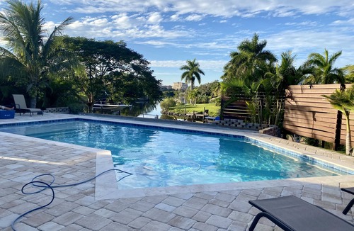 Sarasota House | Waterfront ranch home near Siesta Key with pool overlooking canal and kayaks.