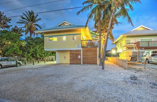 Marathon House | Waterfront Remodeled Home w/Private 35’ Boat Dock - at the foot of the iconic 7-Mile Bridge. Cozy house, water views, outdoor entertaining, private XL hot tub, walk to Sunset Grill for pool. Perfect for fishing, boaters, divers & sunset lovers.