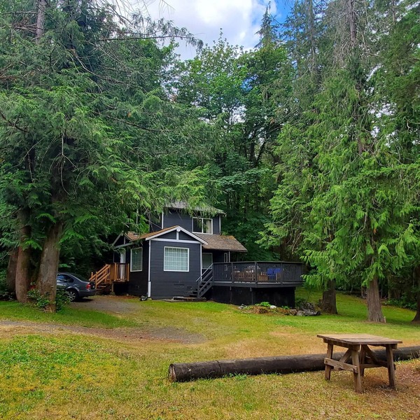 Riverfront cottage with stairs to the river, firepit, and forested retreat.