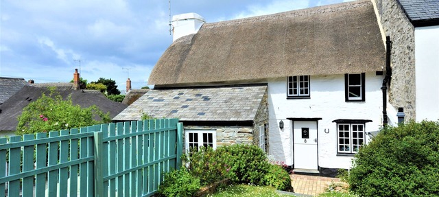 Charming Listed Thatched Cottage with parking and short walk to sandy beach .
