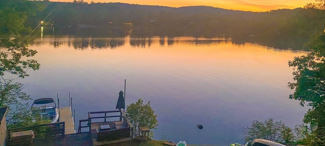 Lakefront home near ski resorts with water view, dock, deck, fireplaces, & W/D