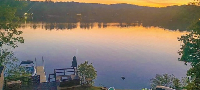 Lakefront home near ski resorts with water view, dock, deck, fireplaces, & W/D