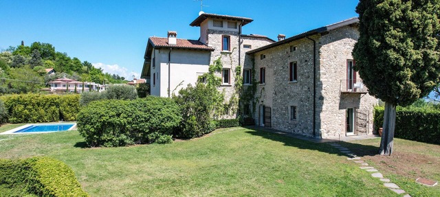 Luxurious villa surrounded by greenery with swimming pool and lake view