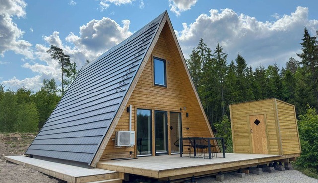 A Frame cottage surrounded by a forest, incl sauna
