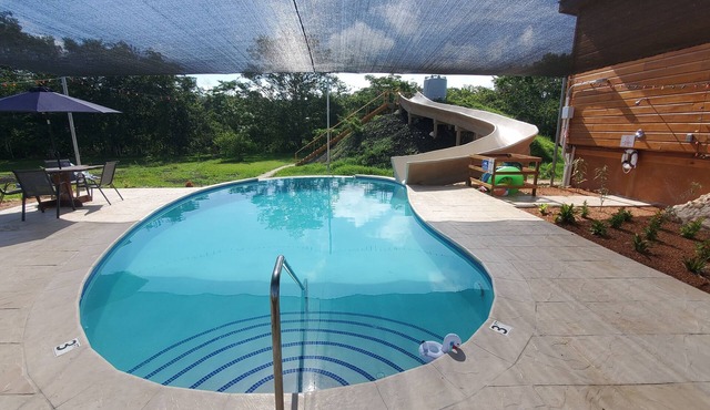 A stunning private estate situated on 6.5 acres along the Mopan River with pool and water slide.