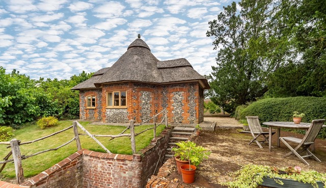A unique octagonal brick and flint thatched Victorian cottage nestling in a tranquil village locatio