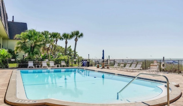 Beachfront condo with a view of the water, a pool, a sundeck, a private balcony, and a washer and dryer