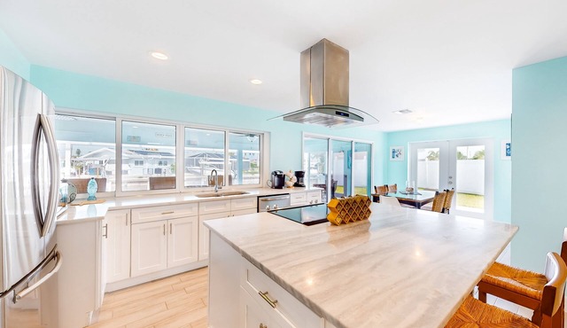 Canal-front home with heated saltwater pool, dock, grill, & covered patio