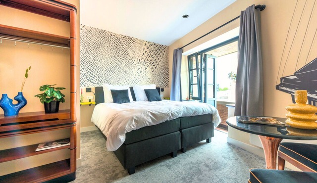 Experience the unique De Stijl–inspired design of Nelly van Doesburg in this affordable, stylish suite in central Tilburg. A smart choice for travelers who value fast Wi-Fi, comfort, and a prime city location.