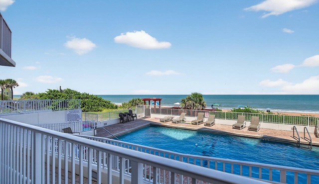Ground floor direct oceanfront 2/2 with a balcony, heated pool, and garage parking