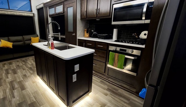 Luxury RV with full kitchen sleeps family of 6 inside fenced property
