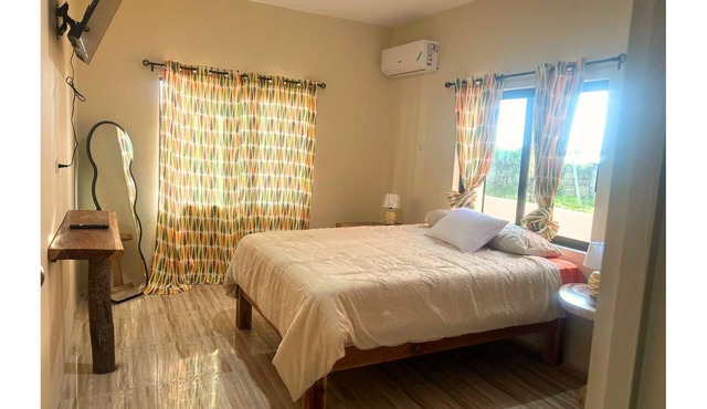 Minimalist queen suite with soothing décor and ensuite bathroom for quiet reflection.