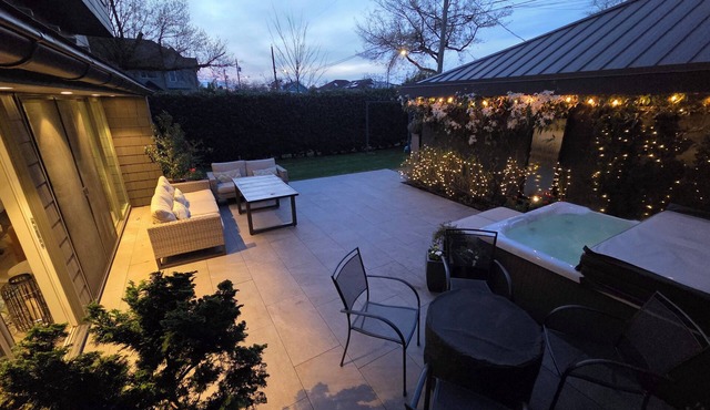 Modern home on a corner lot with large lawn area and patio with hot tub.