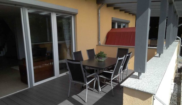 Modern semi-detached house with covered terrace and fenced garden.