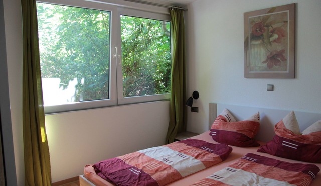 Modernly furnished bungalow with fireplace, surrounded by greenery.