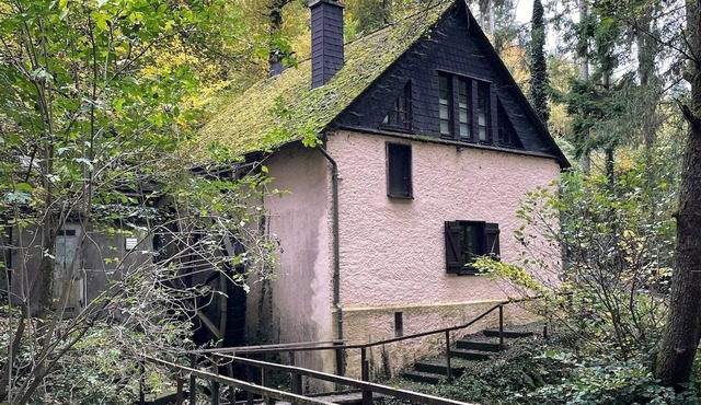 Old farm mill with a water wheel rebuilt as a vacation home