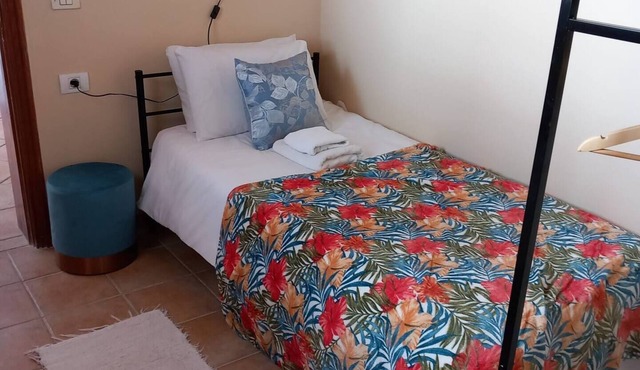 Single room with a single bed and en-suite bathroom. The window looks out onto the patio area
