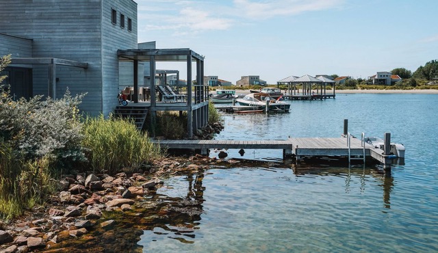 Spacious beach villa with private swimming jetty and a terrace on the water.