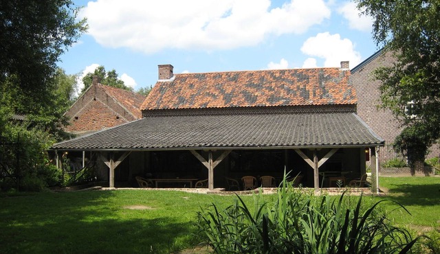 Square-shaped farmhouse in a rural area.